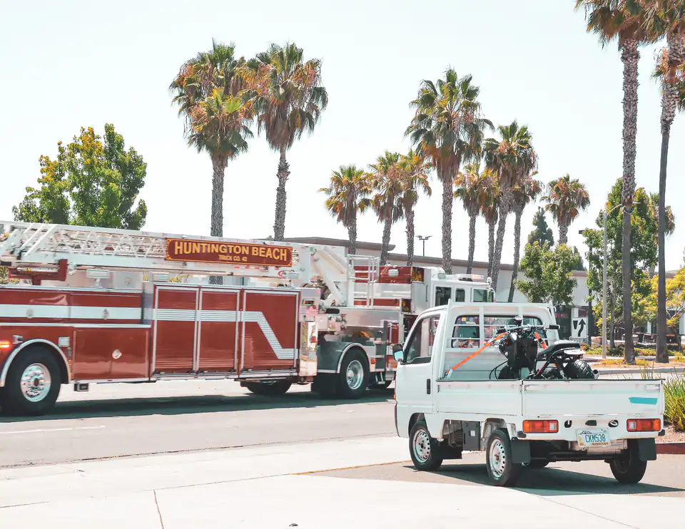 Honda Acty Kei Truck parked beside a full-size fire engine, showing how compact Kei Trucks are