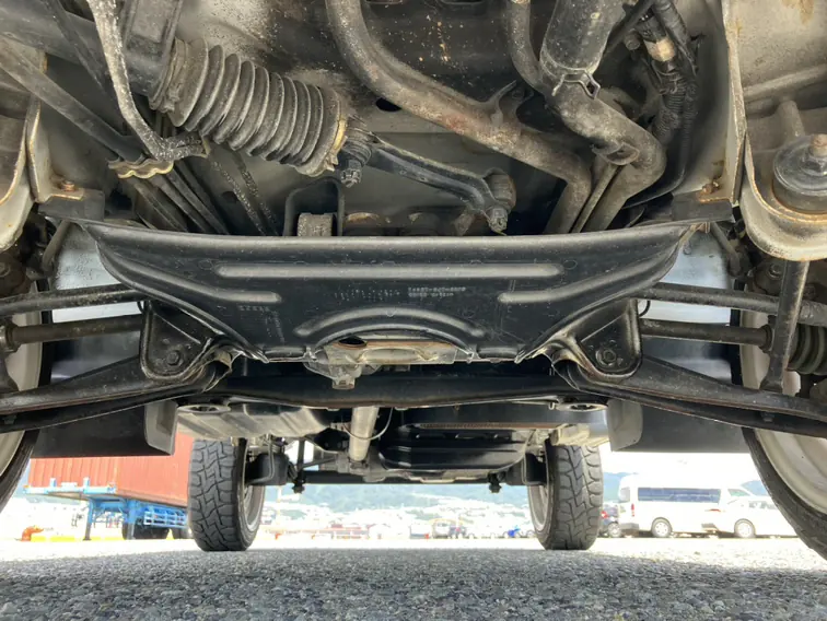 Underside of a Honda Acty showing the suspension, driveshaft and frame during a rust inspection