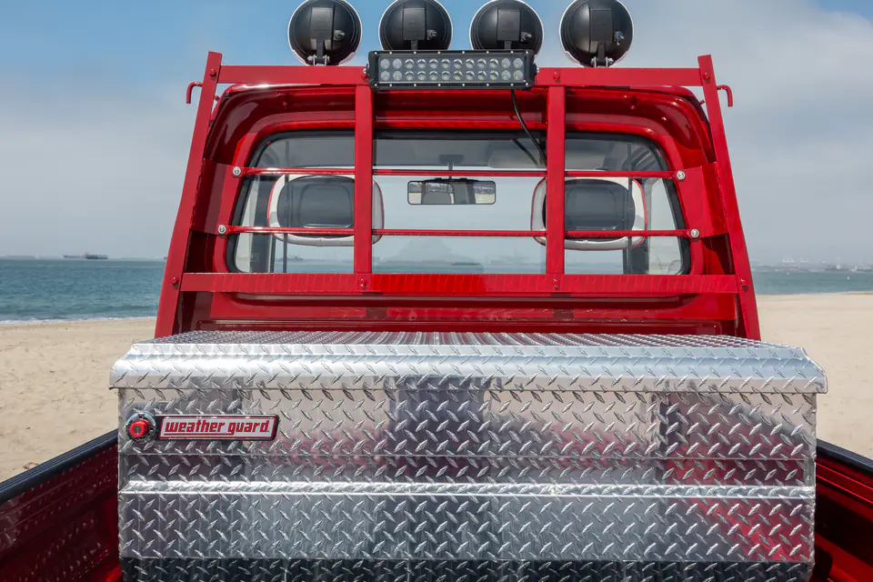 Red Honda Acty with a headache rack, roof lights, LED light bar and diamond plate toolbox