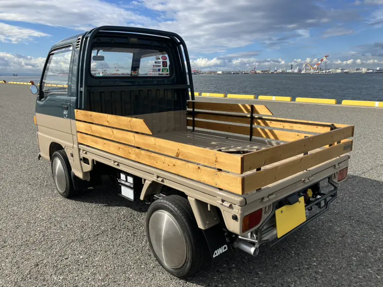 Rear three-quarter view of a Subaru Sambar Kei Truck with wooden stake bed rails